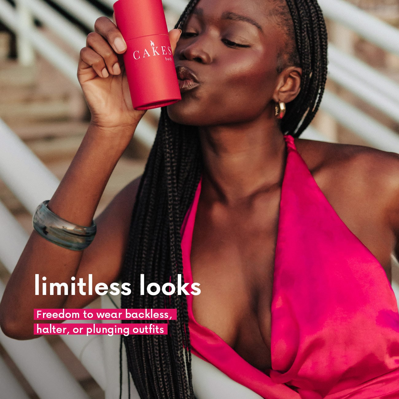 Woman in a pink bikini holding a red cup with 'CAKES' branding, against a blurred outdoor background.
